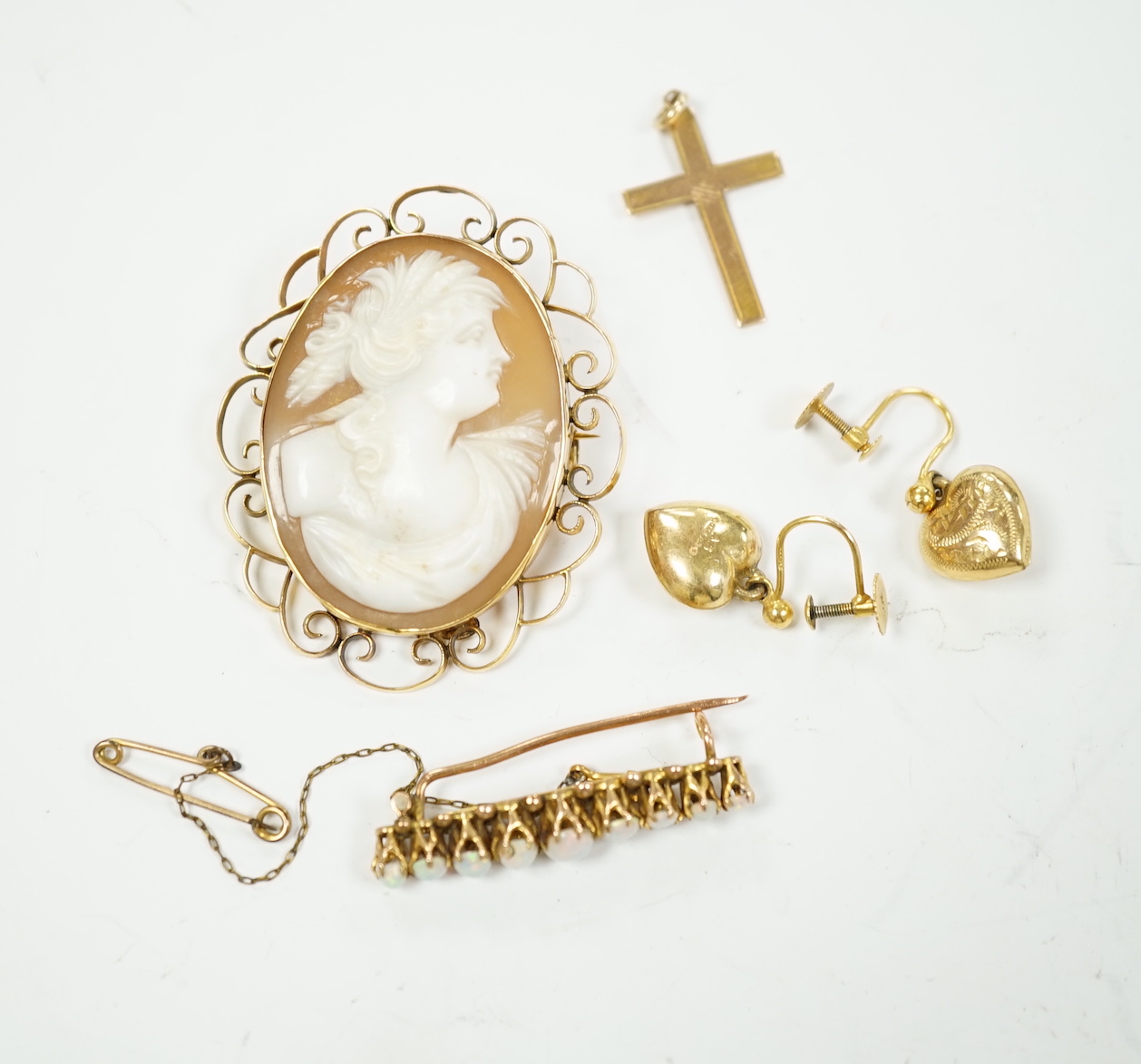 A 9ct and white opal cluster set bar brooch, a 9ct mounted oval cameo shell brooch, a pair of 9ct gold heart shaped drop earrings and a 9ct cross pendant, gross weight 13.4 grams.